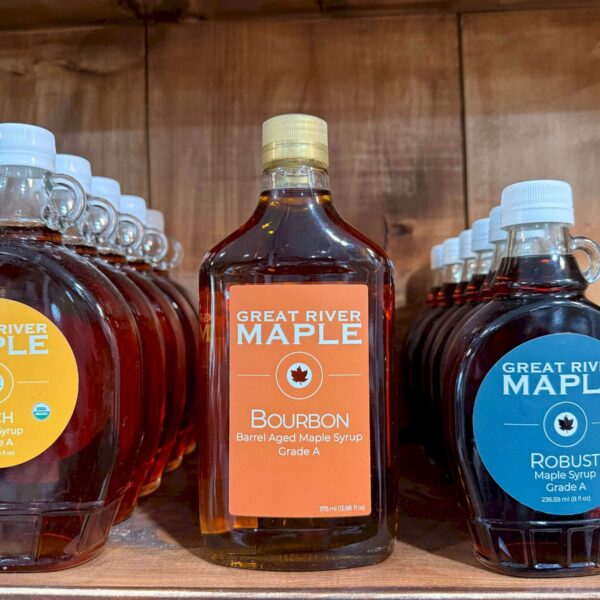 Great River Maple syrup bottles on a shelf.