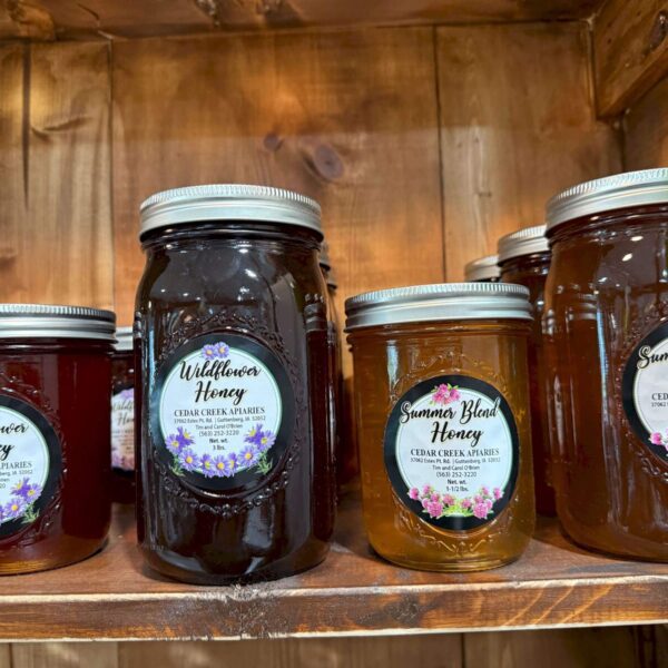 A variety of Cedar Creek Apiaries honey on a shelf.